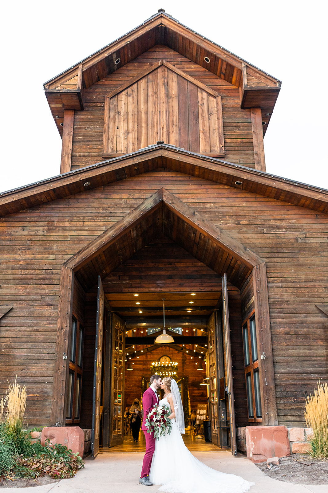 bride and groom in front of rustic venue