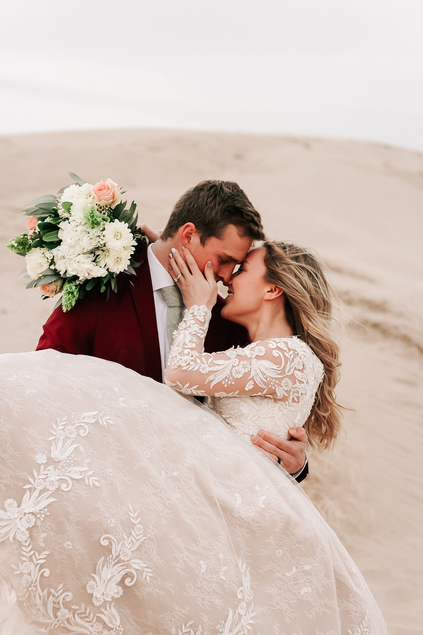 groom in velvet suit with bride in lace wedding dress in utah desert
